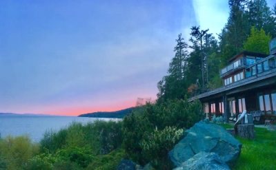 The lodge and front yard under a pink sunset